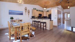 Una cocina amplia con armarios de madera, un comedor con mesa y sillas de madera, y un ventilador de techo.