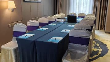 A conference room with a long table, chairs, and a laptop.