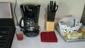 A kitchen counter with a coffee maker, a red cloth, and a box of coffee creamer. - Jane's Hideaway (Frederiksted)