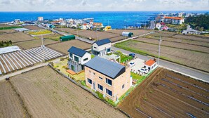Un quartier résidentiel avec des maisons modernes, une route et des champs.