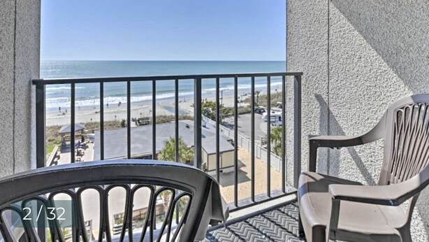 A balcony with a view of the beach, two chairs, and a railing. - Beautiful view At Myrtle Beach Resort (Myrtle Beach)