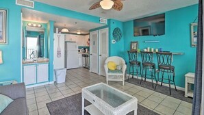 A compact living space with a kitchenette, a dining area with bar stools, a ceiling fan, and a television. - Beautiful view At Myrtle Beach Resort (Myrtle Beach)