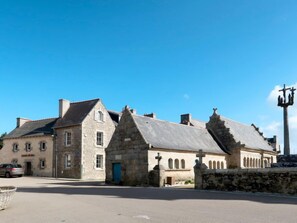A stone building with a steep roof, a blue door, and a sign that reads "Hotel de France".