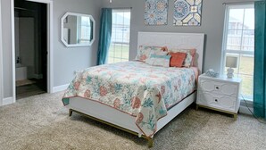A bedroom with a bed, a nightstand, a ceiling fan, and two windows with curtains. - MODERN HOME - firepit & fenced in backyard! (Carl Junction)