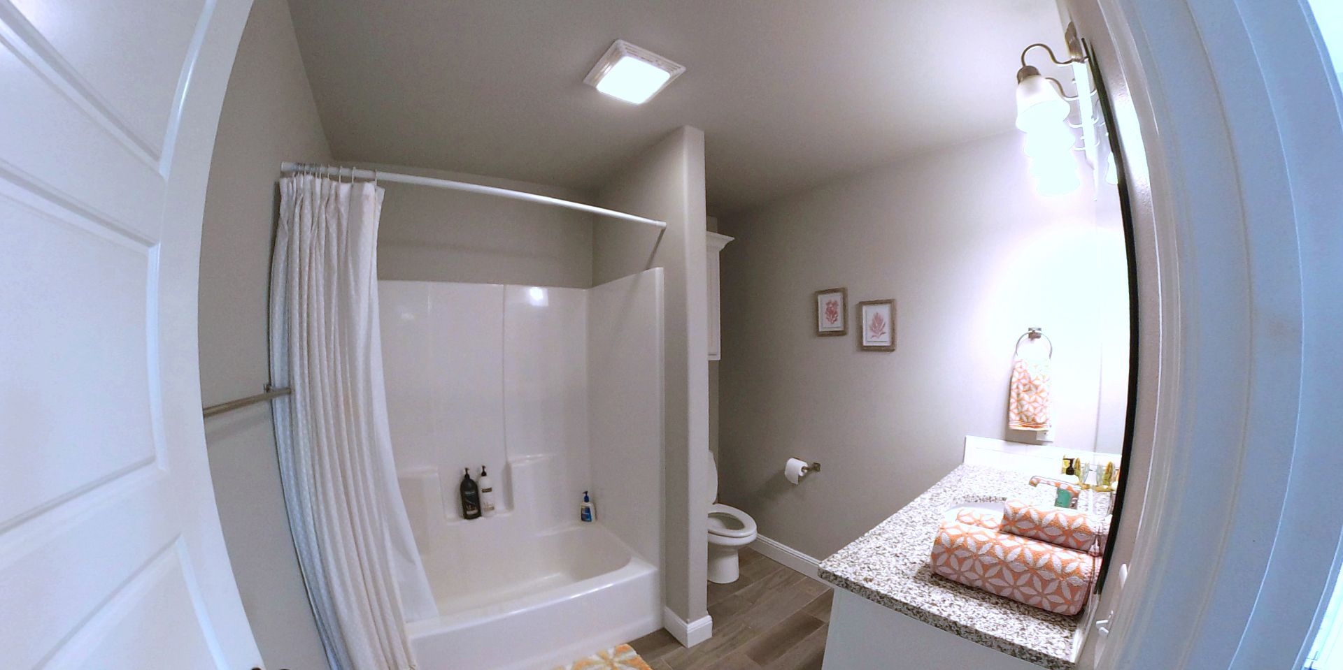 A bathroom with a shower, toilet, and sink.