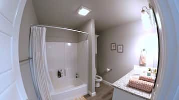 A bathroom with a shower, toilet, and sink.