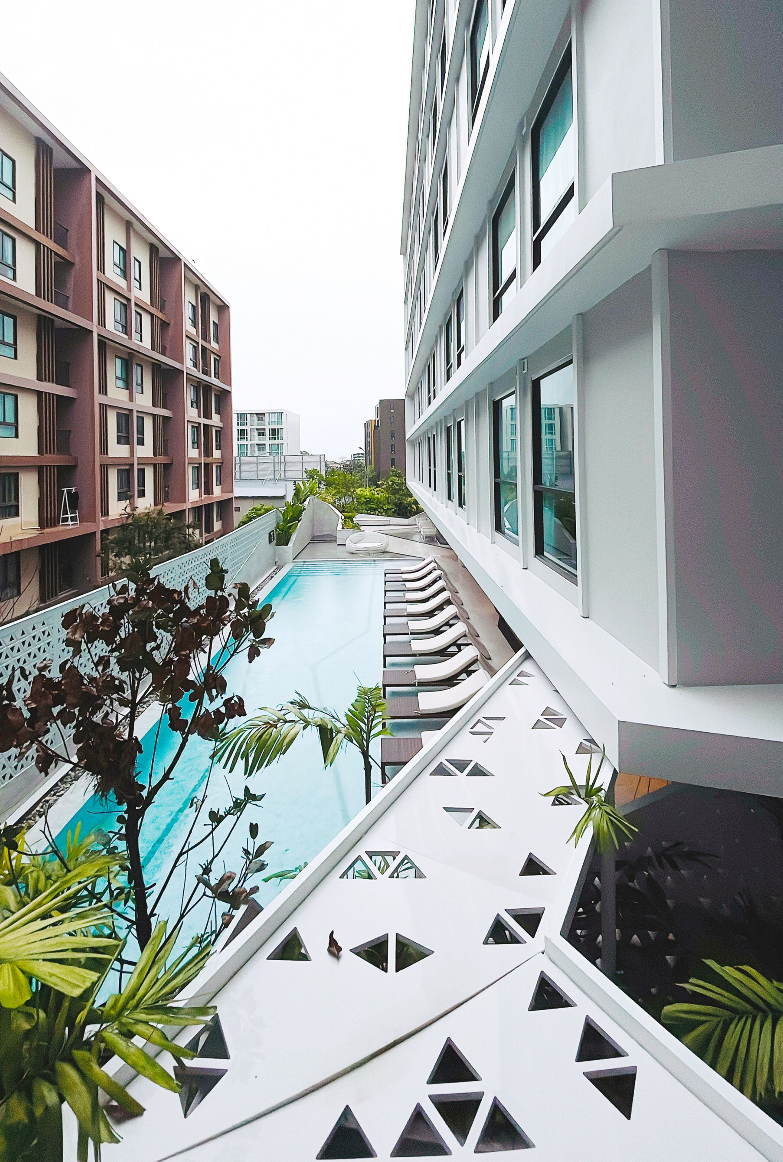 A modern building with a pool and outdoor seating area.