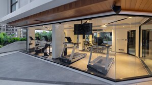 A modern fitness center with treadmills and exercise equipment. - Travelodge Phuket Town (Wichit)