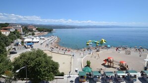 Une zone côtière comprenant une plage, une aire de jeux et un parking.