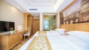 A hotel room with a bed, a desk with a chair, a television, and a painting of a bridge. - Vienna International Hotel (Hubei Yichang East Railway Station Wuyi Square) (Yichang)