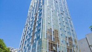 A tall, modern glass building with a grid-like facade. - Vienna International Hotel (Hubei Yichang East Railway Station Wuyi Square) (Yichang)