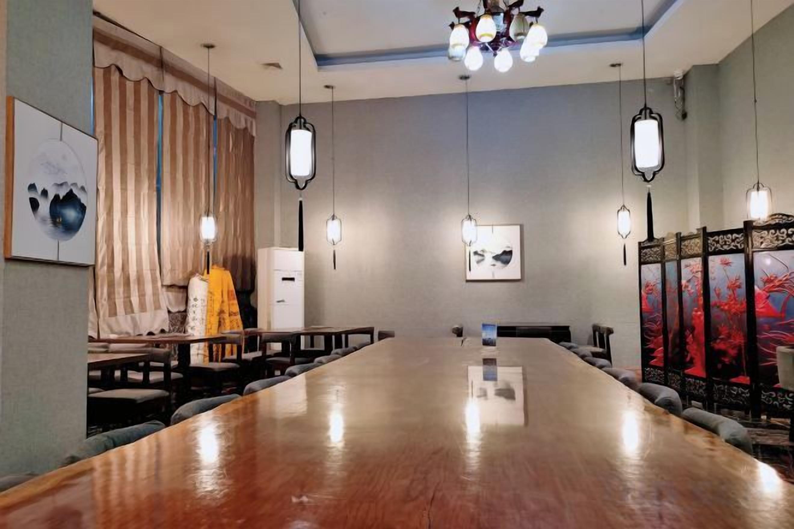 Una sala de conferencias con una larga mesa, sillas, una pizarra y obras de arte en las paredes.