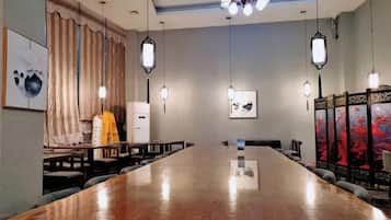 Una sala de conferencias con una larga mesa, sillas, una pizarra y obras de arte en las paredes.