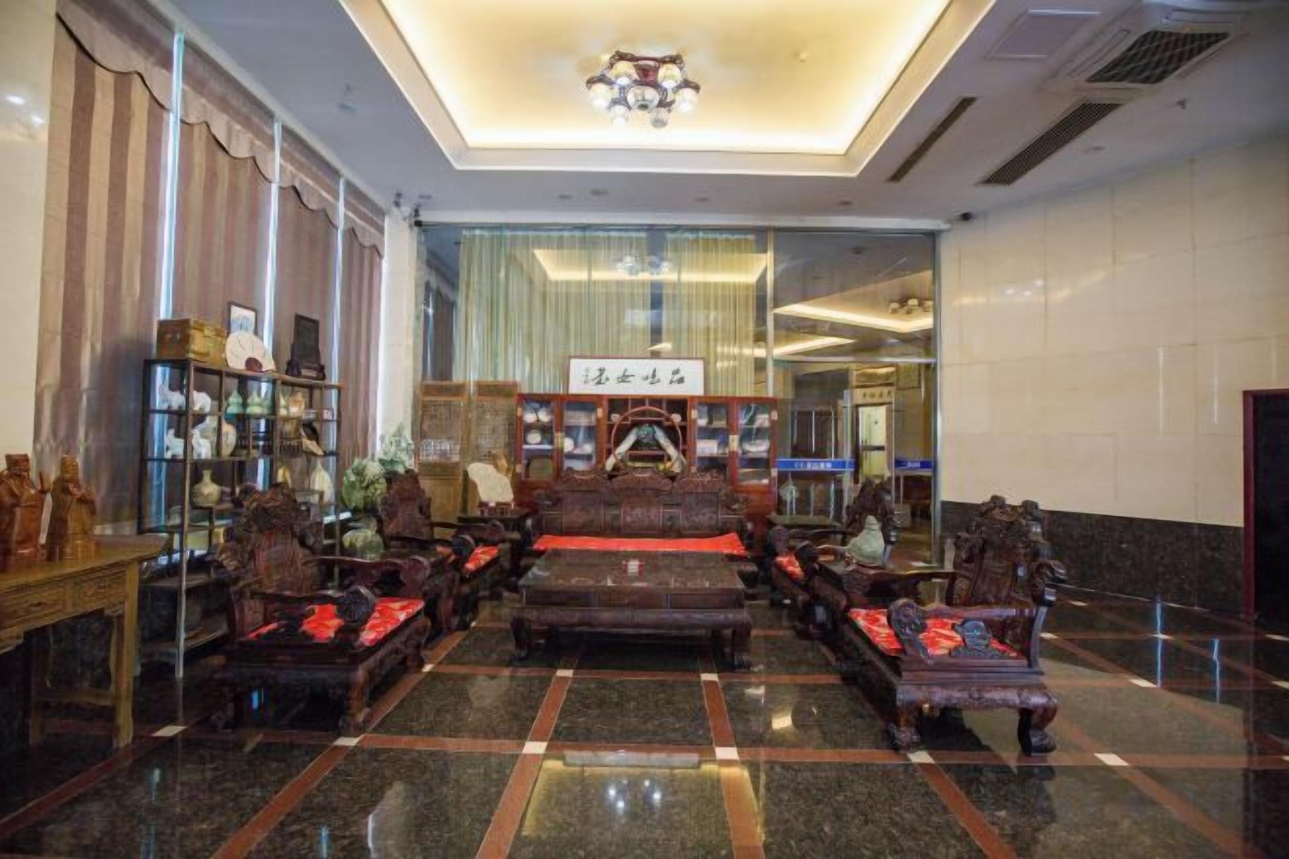 A lobby with traditional furniture, a reception desk, and a glass partition.