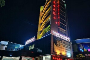 Een meerlaags gebouw met verlichte borden, waaronder een opvallend 'BOSS'-bord.