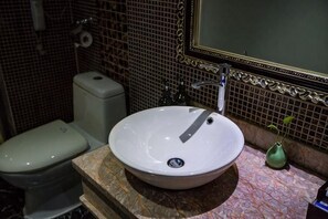 A bathroom with a white sink, a toilet, and a mirror. - Nvshu Hotel (Jiangyong)