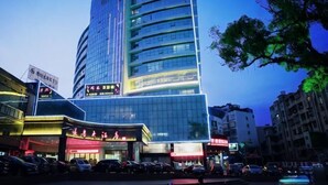Un hôtel moderne à la façade incurvée, doté de plusieurs étages et d’une enseigne lumineuse.
