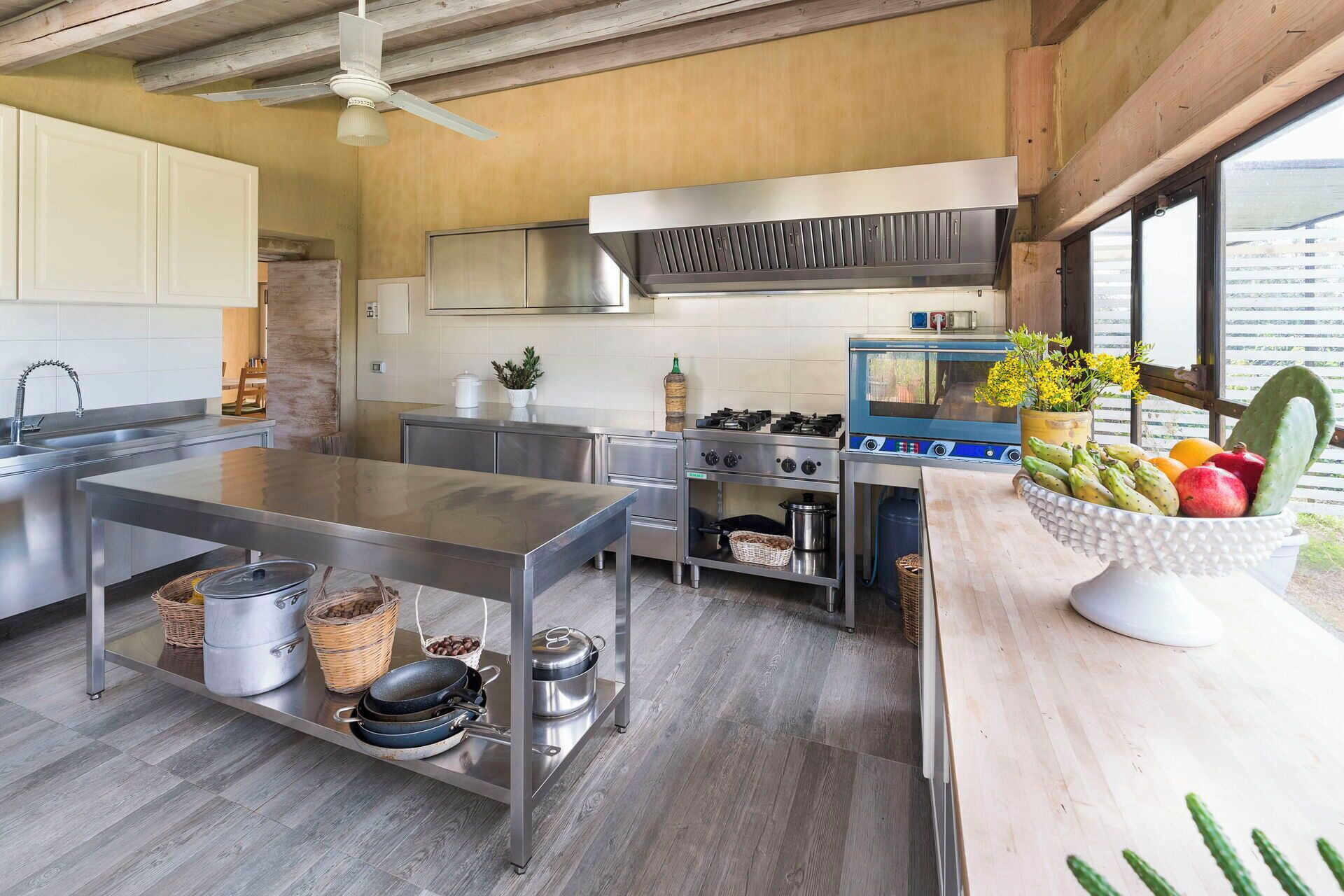A modern kitchen with stainless steel appliances, a central island, and a view of the outdoors.