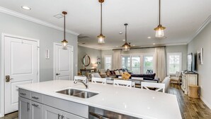 A modern kitchen with a large island, stainless steel appliances, and pendant lighting. - Closest Complex to Community Pool | Electric Car Charging Outlet | Private Beach Club | Golf |Tennis (Pensacola)