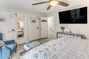 A bedroom with a bed, a ceiling fan, a TV, a dresser, and a closet with a sign reading 'Captains Quarters'.