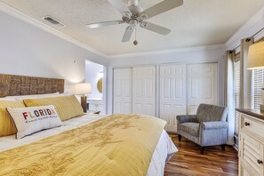 A bedroom with a bed, a chair, a ceiling fan, and a wardrobe. - SPC 3203 - Recently Upgraded Pet Friendly 2 BR at Sandpiper Cove - Gorgeous unit by RedAwning (Destin)