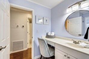 A bathroom with a white vanity, a large mirror, and a door leading to another room. - SPC 3203 - Recently Upgraded Pet Friendly 2 BR at Sandpiper Cove - Gorgeous unit by RedAwning (Destin)