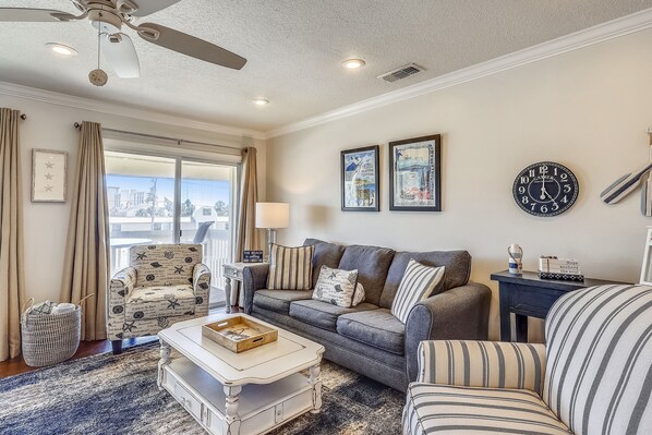 A living room with a sofa, armchairs, a coffee table, a side table, and a clock on the wall. - SPC 3203 - Recently Upgraded Pet Friendly 2 BR at Sandpiper Cove - Gorgeous unit by RedAwning (Destin)