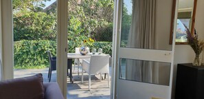 Enjoy a serene view from the comfort of your room, with access to a patio surrounded by lush greenery.