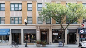 A multi-story building with a boutique gallery on the ground floor, a hair salon on the second floor, and a business with a sign for studios for rent. - Rustic Studio Apartment in the Heart of Lincoln Square (Chicago)