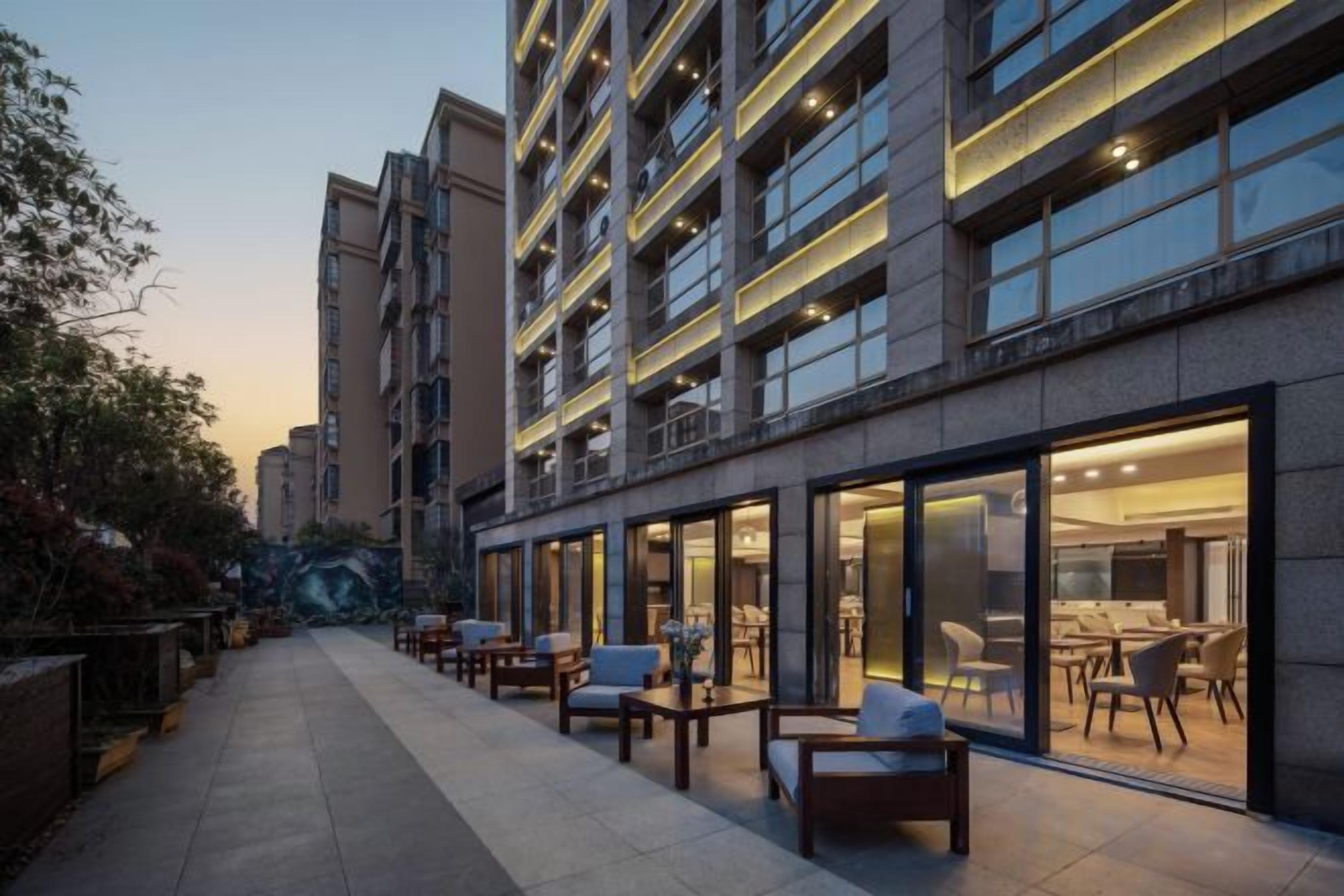 Un hôtel doté d’une terrasse, de grandes fenêtres et d’un design moderne.