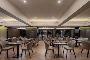 A restaurant with multiple tables and chairs, a wooden floor, and a modern ceiling design. - Hengchu Sunshine Hotel (Ningxiang)