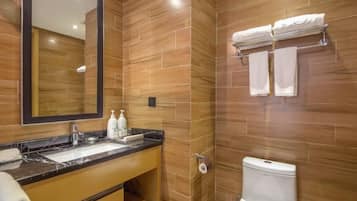 Un baño moderno con lavamanos de mármol, paredes de madera, inodoro y perchero.