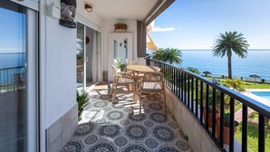 A balcony with a table and chairs, a view of the sea, and a pool. - Acapulco Playa 302 by Casasol (Nerja)