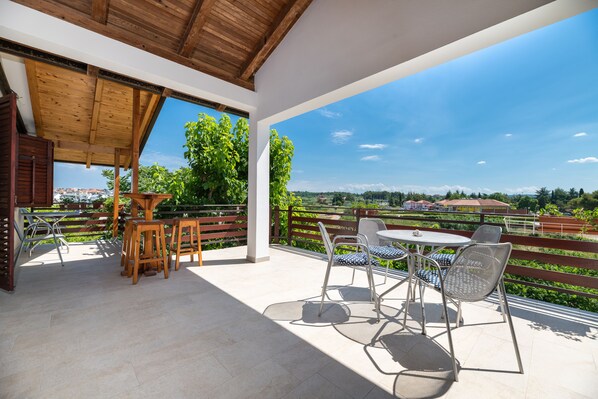Eine Terrasse im Freien mit Holzmöbeln und Blick auf die Landschaft.