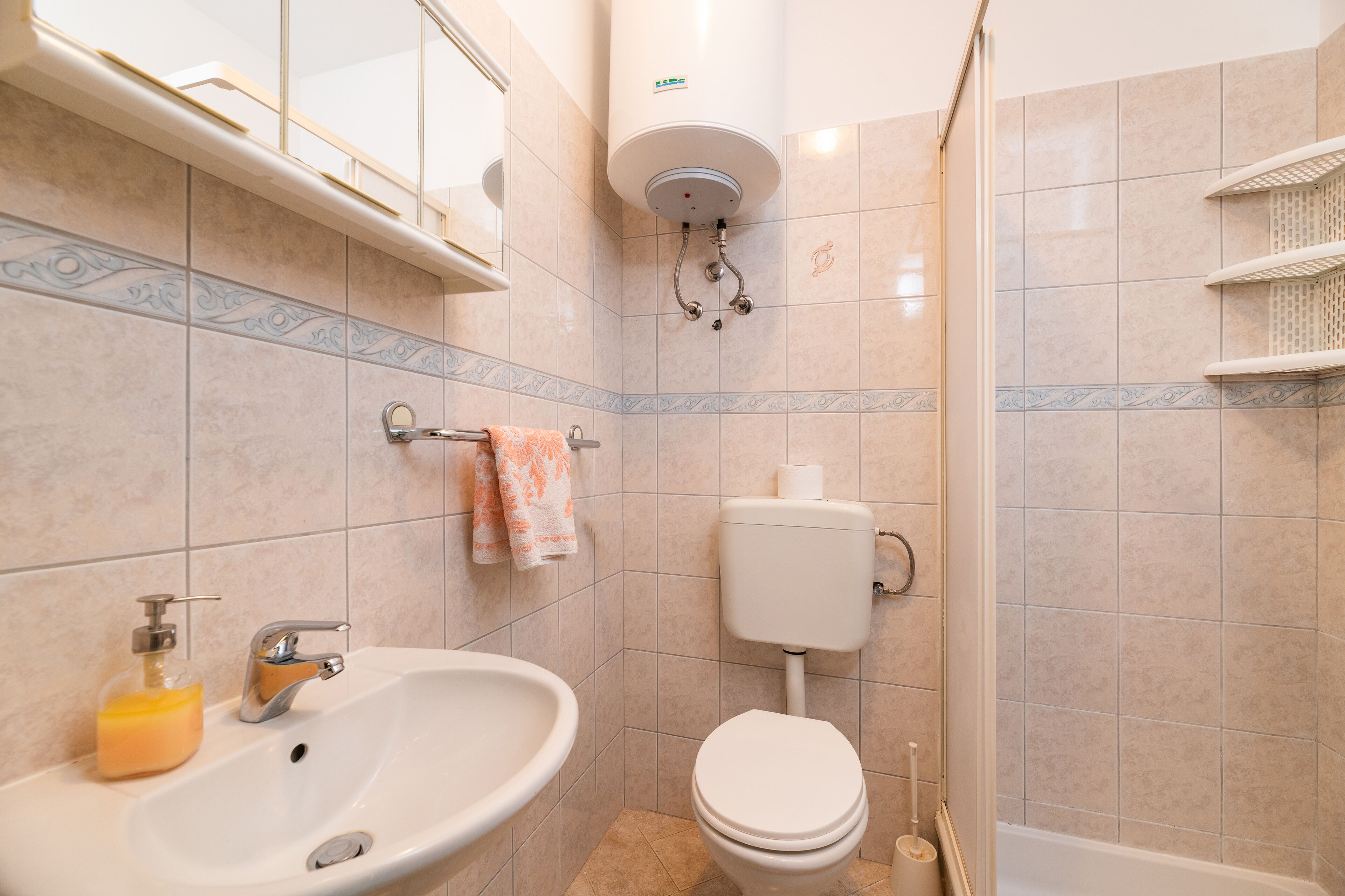 A bathroom with a sink, toilet, and shower.