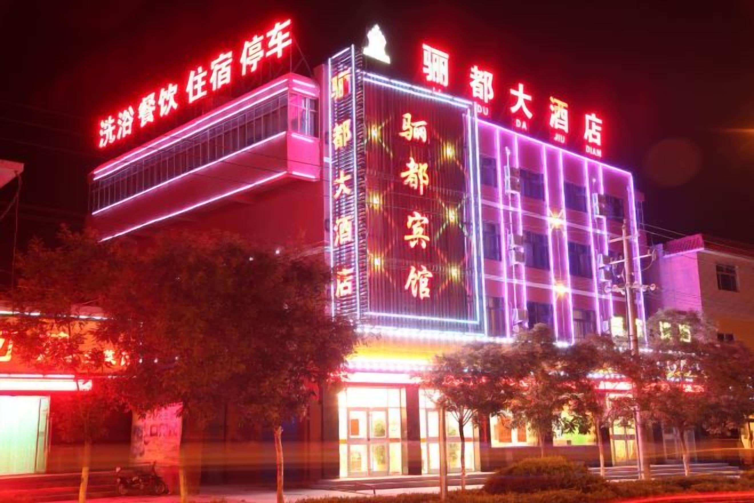 A hotel with illuminated signage and a modern facade.
