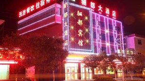 A hotel with illuminated signage in red and white, featuring the name and services offered. - Yongchang Lidu Hotel (Yongchang)