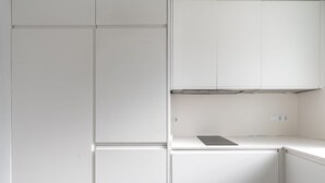 A modern kitchen with white cabinetry and a built-in stove. - Ponce Léon. 1-bedroom, private terrace. (Sevilla)