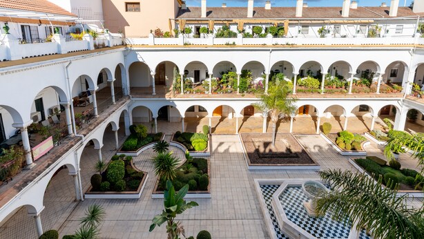 A courtyard with multiple arches, potted plants, and a checkered fountain. - Ponce Léon. 1-bedroom, private terrace. (Sevilla)
