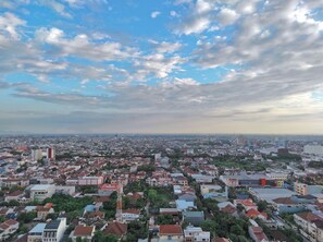 Un paysage urbain mêlant des immeubles résidentiels et commerciaux, une tour imposante et un ciel dégagé parsemé de quelques nuages.