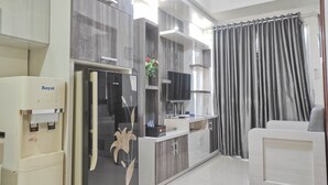 A modern kitchen with a built-in refrigerator, a water dispenser, and a flat-screen TV. - Best Deal And Cozy 2Br Vida View Apartment (Makassar)