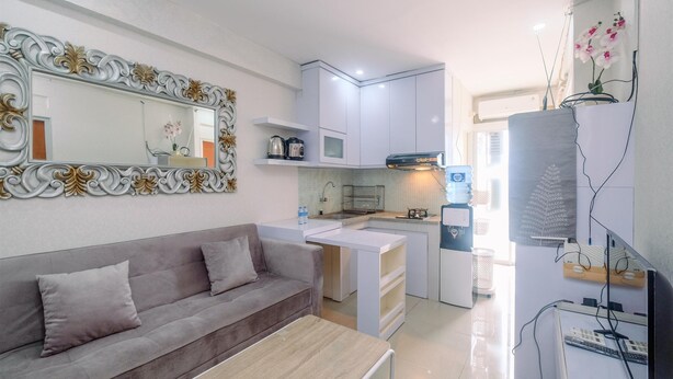 A modern kitchen with white cabinets, a built-in microwave, and a sink. - Simple And Cozy Living 2Br At Cibubur Village Apartment (Depok)