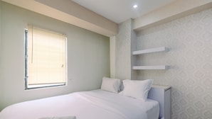 A bedroom with a bed, a window, and a wall-mounted shelf. - Simple And Cozy Living 2Br At Cibubur Village Apartment (Depok)