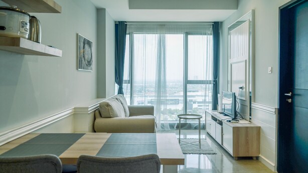 Een moderne woonkamer met een bank, een eettafel en een keuken met een televisie.