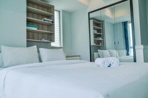 Enjoy a restful stay in this stylish room featuring a comfortable bed, large mirror, and shelving unit.