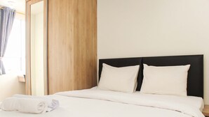 A neatly made bed with white linens and pillows, a wooden headboard, and a window with curtains. - Comfortable 2Br Apartment At Mustika Golf Residence (Cikarang)