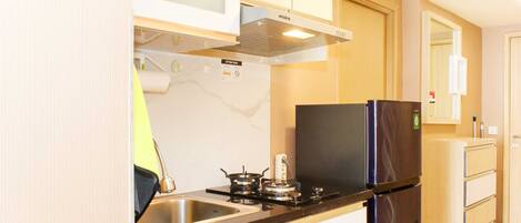 A compact kitchen with a stove, sink, and refrigerator.