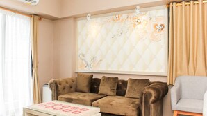 Un salon avec un canapé marron, une table basse blanche et un fauteuil gris.