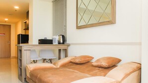 Un dormitorio con una cama, un escritorio con una silla, un televisor y una ventana con persianas.