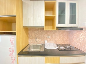 A kitchen with a sink, stove, and cabinets. - Comfy And Relax 1Br Apartment At Parahyangan Residence Near Unpar (Bandung)